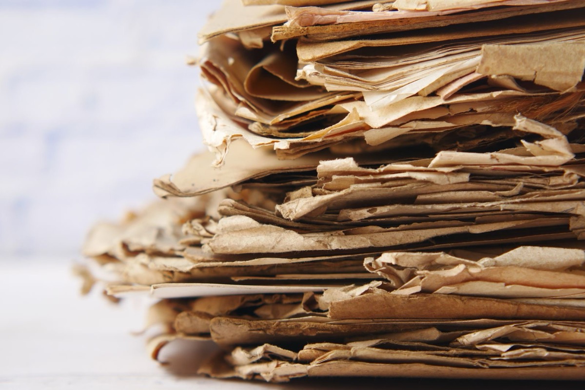 A tall stack of old, curled brown papers